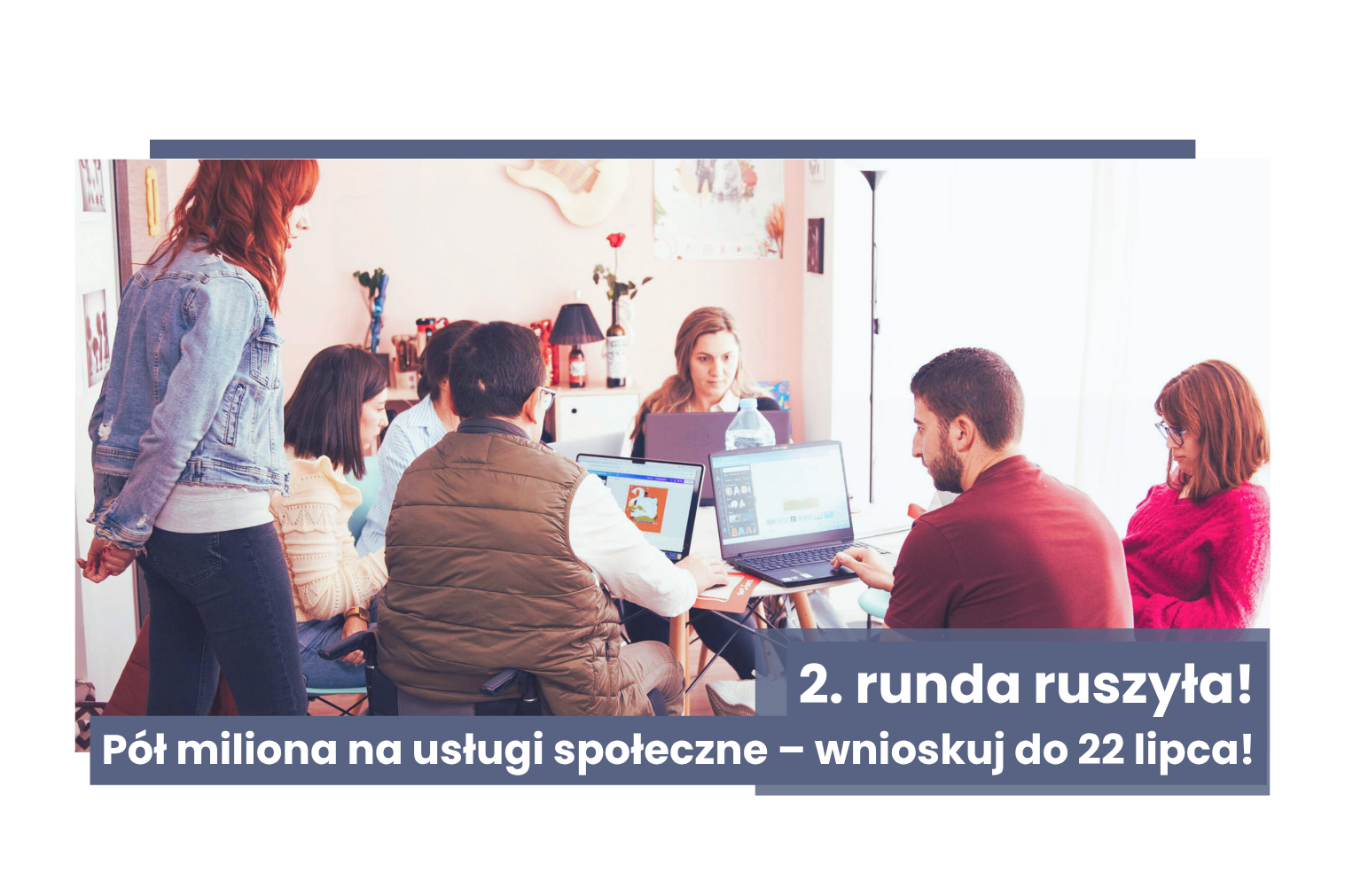 Grupa ludzi siedząca wokół stołu z laptopami
